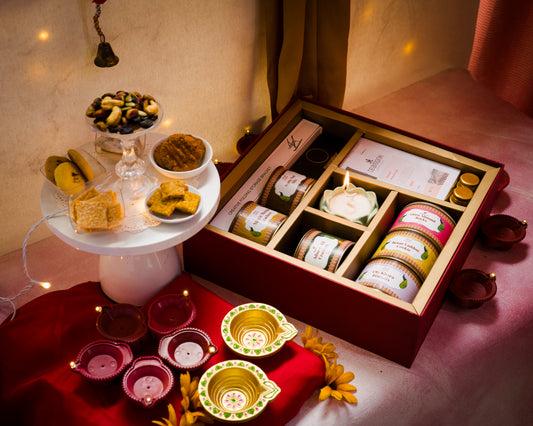 Desi gourmet gifting hamper for employees, individuals to bring them closer together. It's a gift hamper containing our desi inspired cookies and some merch surrounded by fairy lights and diya to bring in the festive element